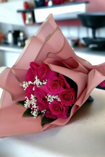 Mother’s Day pink rose bouquet with baby’s breath wrapped in elegant paper on a modern countertop