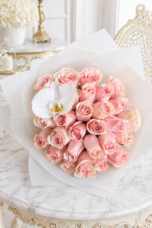 Mother’s Day bouquet with blush pink roses and white orchid on elegant marble table