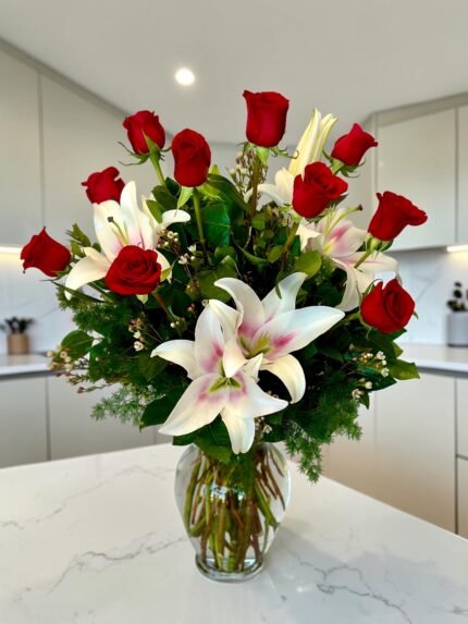 Mother’s Day roses and lily bouquet in vase on elegant coffe table of marbel